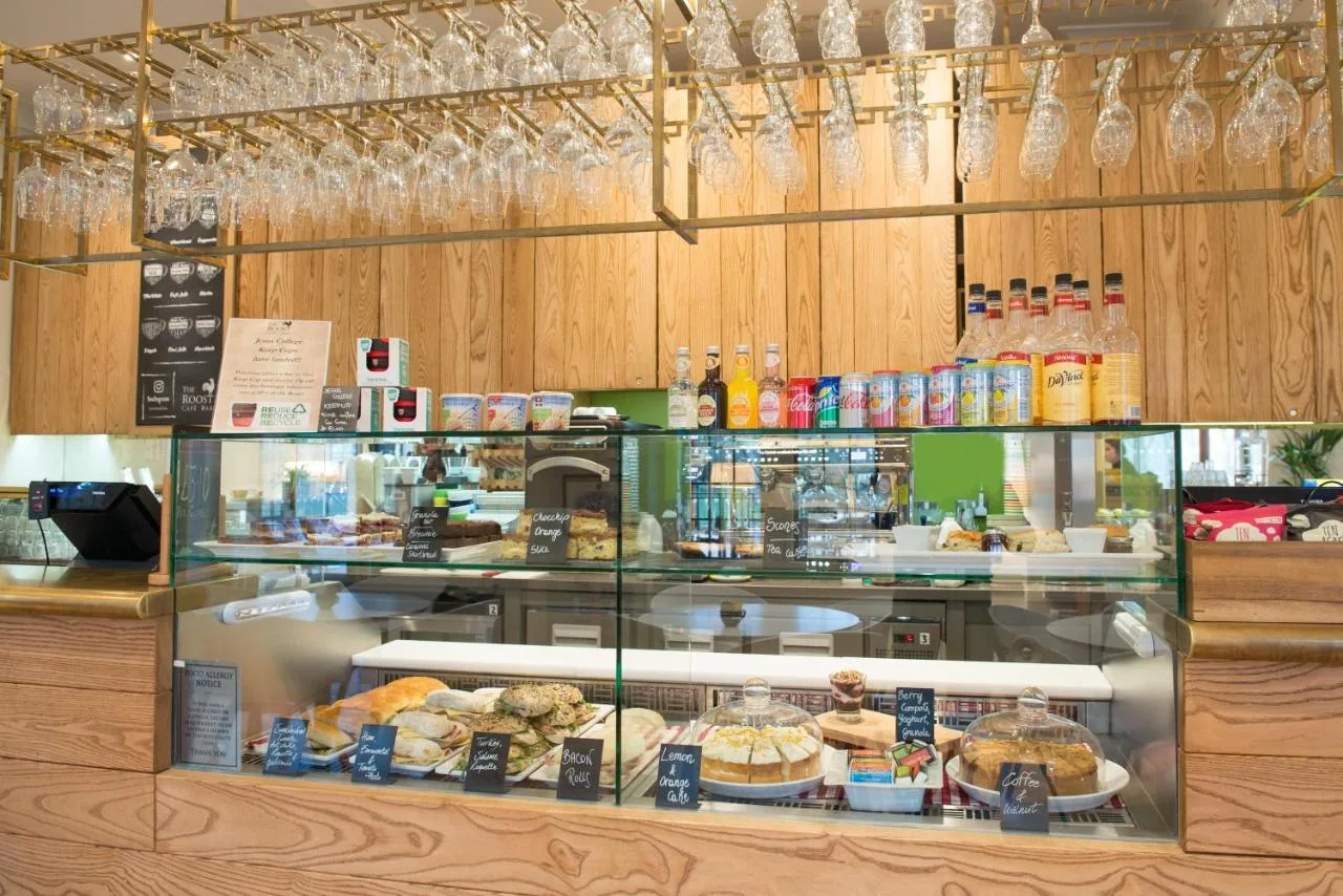 a bakery with a display case filled with food at West Court- Jesus College in Cambridge