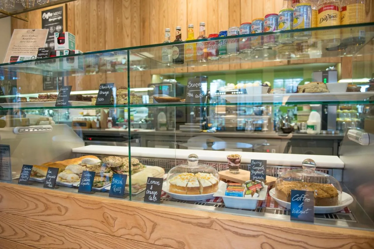 a bakery display case with many different types of pastries at West Court- Jesus College in Cambridge
